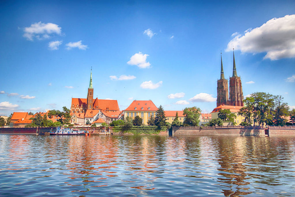 WROCLAW, POLAND - JULY 18, 2017: Wroclaw Old Town. Cathedral Island (Ostrow Tumski) is the oldest part of the city. Odra River, boats and historic buildings on a summer day. - Foto, immagini