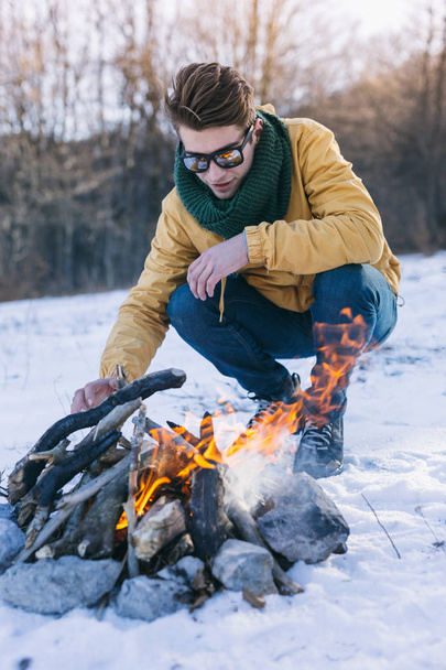 Man on mountain relaxing at campfire - Valokuva, kuva