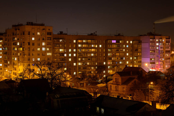 Photo de bâtiments résidentiels la nuit avec fumée d'usine au-dessus d'eux
 - Photo, image