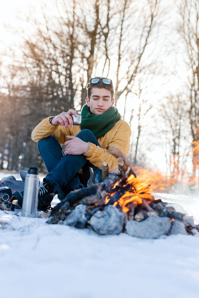 Man on mountain relaxing at campfire - Фото, изображение