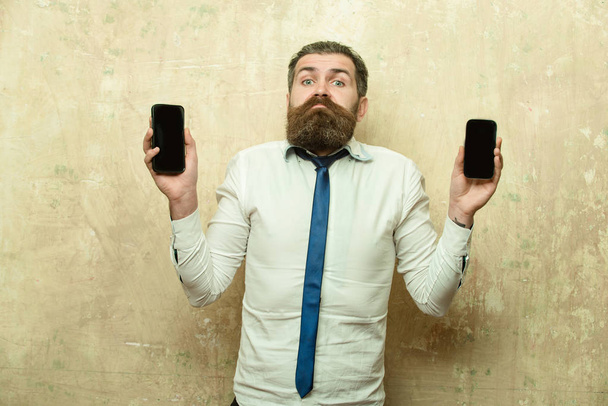 manager or bearded man compare mobile phone and smartphone - Foto, immagini