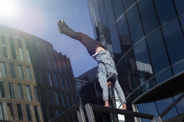 Young man doing handstand in the city - 写真・画像
