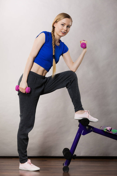 Teenage woman working out at home with dumbbell - Φωτογραφία, εικόνα