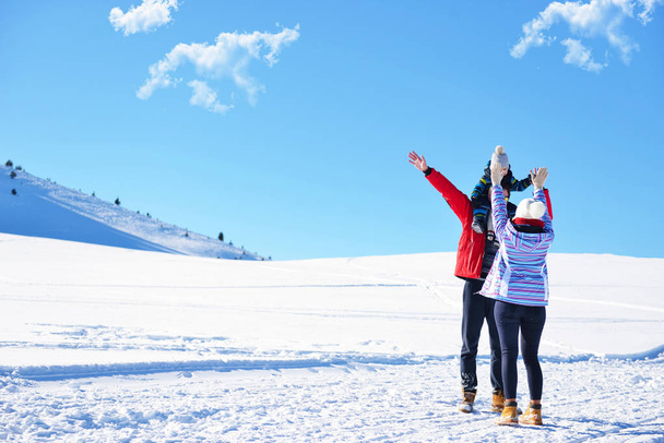 happy young family playing in fresh snow at beautiful sunny winter day outdoor in nature - 写真・画像