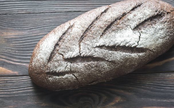 Rye bread on the wooden background - Fotoğraf, Görsel