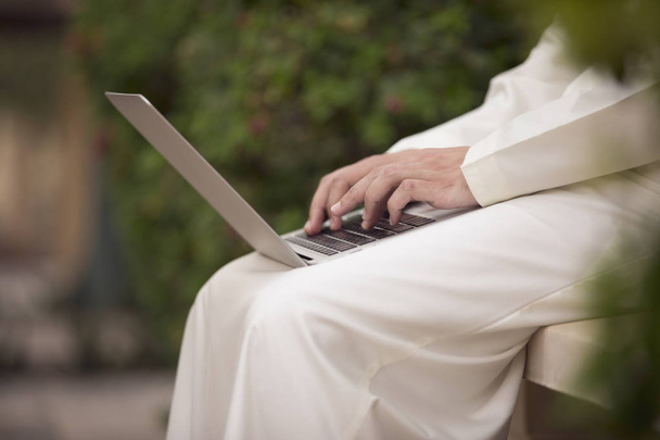 Emiraty młody człowiek siedzi i praca z laptopem - Zdjęcie, obraz