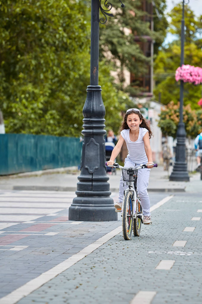 Cute kid in safety helmet biking outdoors. Little girl on a red bicycle Healthy preschool children summer activity. - Foto, Imagem
