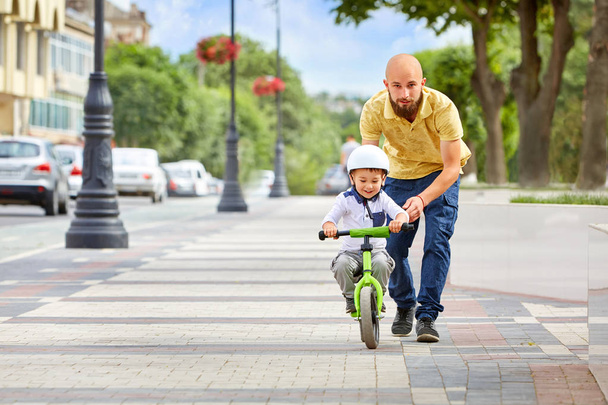 First lessons bicycle riding. Father teach his son to ride a bike. - Foto, Imagen