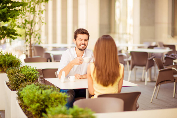 Young cheerful guy on a date in cafe outdoors, smiling, talking  - Fotografie, Obrázek
