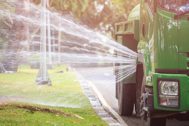 Water truck spraying water to landscape in the public park in Ph - 写真・画像