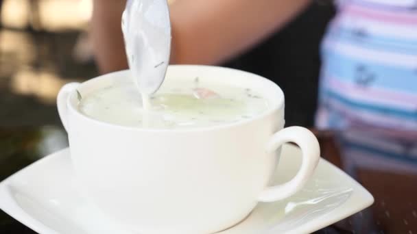 A kefir - orosz hideg leves és a kéz Okroshka a leves keverje meg egy kanállal. 4 k, közelkép, lassú mozgás. - Felvétel, videó