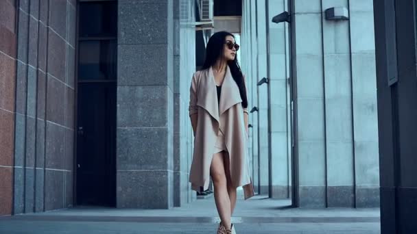 süße und hinreißende asiatische Frau im Mantel, die zwischen den Säulen wandelt - Filmmaterial, Video
