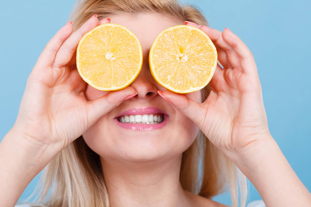 Girl covering her eyes with lemon citrus fruit - Zdjęcie, obraz