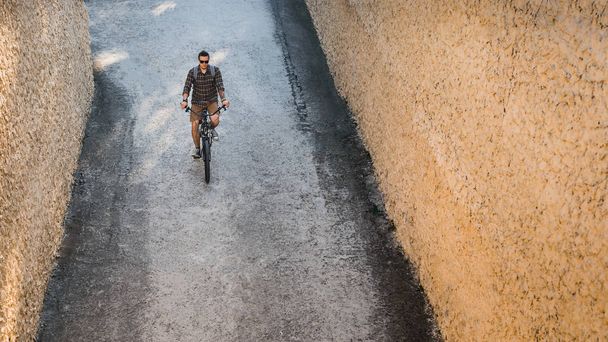 Młody człowiek kolarz jeżdżący na rowerze ulicą, widok z góry. Codziennego życia miejskie, spoczynkowe koncepcja - Zdjęcie, obraz