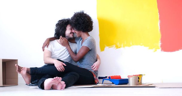 молода багатоетнічна пара розслабляється після фарбування
 - Фото, зображення