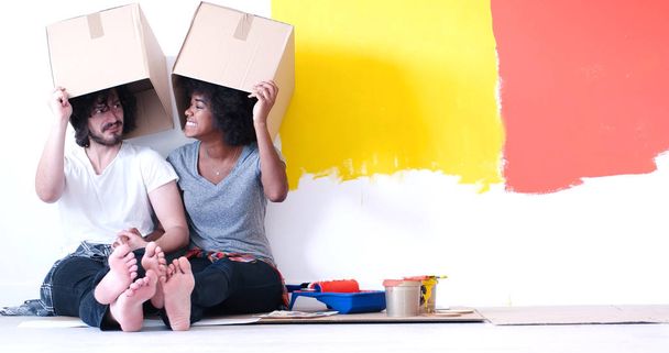 young multiethnic couple playing with cardboard boxes - Foto, imagen