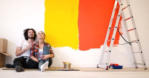 Happy young couple relaxing after painting - 写真・画像