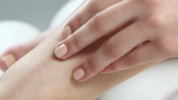 Girl spends her hand over her smooth skin on her leg. Close up - Felvétel, videó