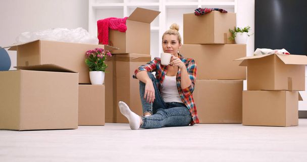 woman with many cardboard boxes sitting on floor - Zdjęcie, obraz