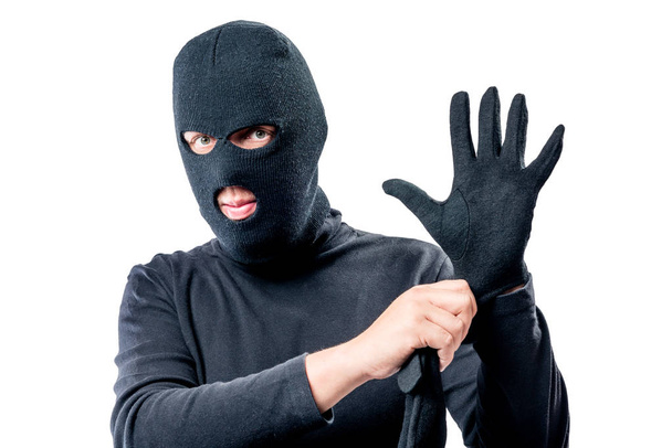 Portrait of a robber in a mask on his face straightens a glove o - Φωτογραφία, εικόνα