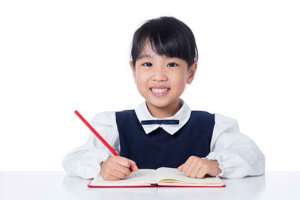 Asian Little Chinese girl writing homework  - Photo, image