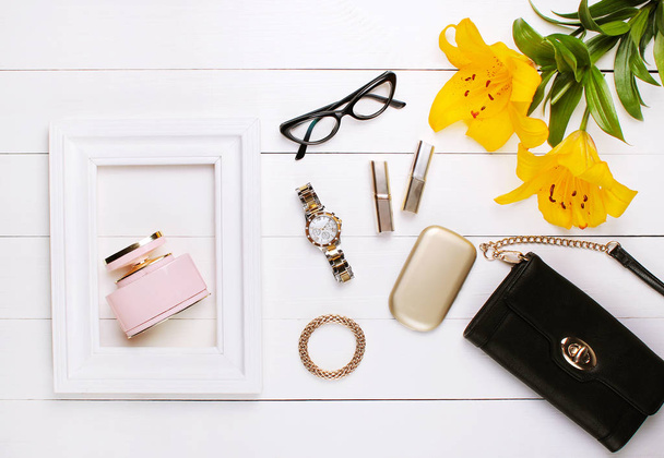 Perfume in a white frame, lily flowers, lipstick and glasses on a white background - Fotoğraf, Görsel