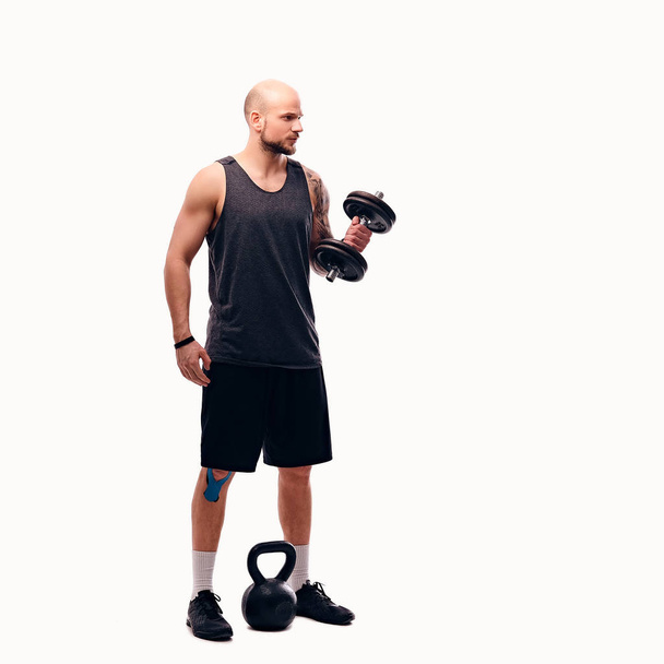 Athletic man holds dumbbell - Фото, зображення
