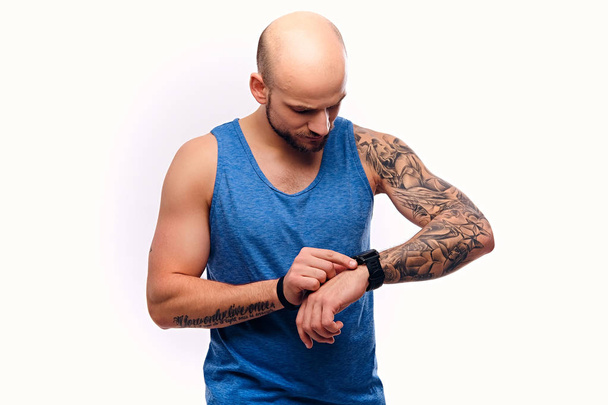 Musculoso hombre viendo en su reloj inteligente
 - Foto, Imagen