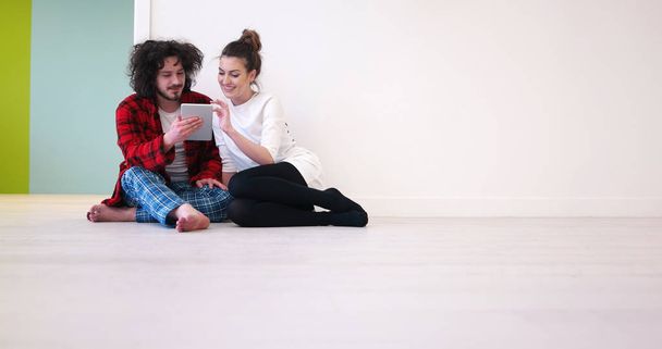Young Couple using digital tablet on the floor - Φωτογραφία, εικόνα
