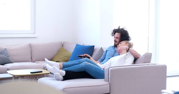 Young couple on the sofa watching television - Foto, Imagen