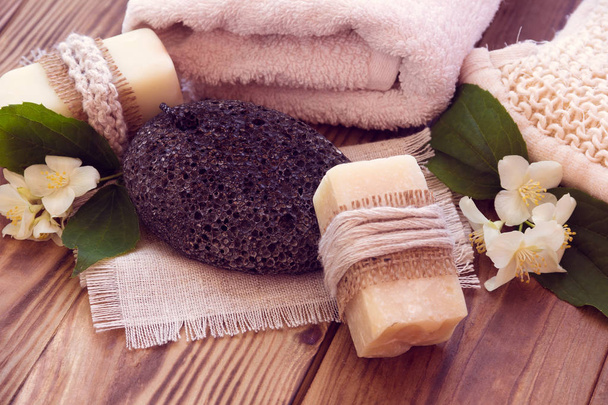 Two pieces of dry soap with a jasmine, towel, pumice and a bast - Photo, Image