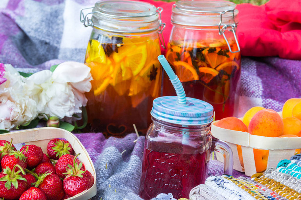 Picnic al aire libre con fresas, albaricoques y bebidas frías
 - Foto, imagen