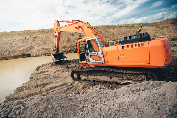 Pelle lourde pendant les travaux de construction de routes. Bulldozer et excavatrice creusant dans le sol
 - Photo, image