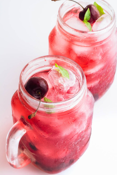 Bebida roja con hielo y cerezas
 - Foto, Imagen