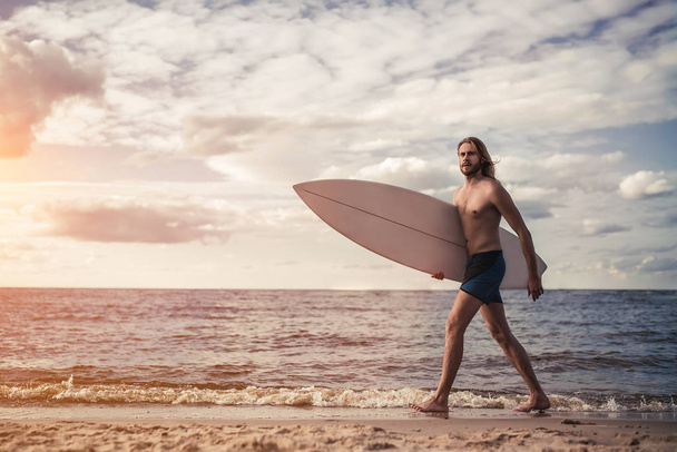 Young man with surfboard - Fotó, kép