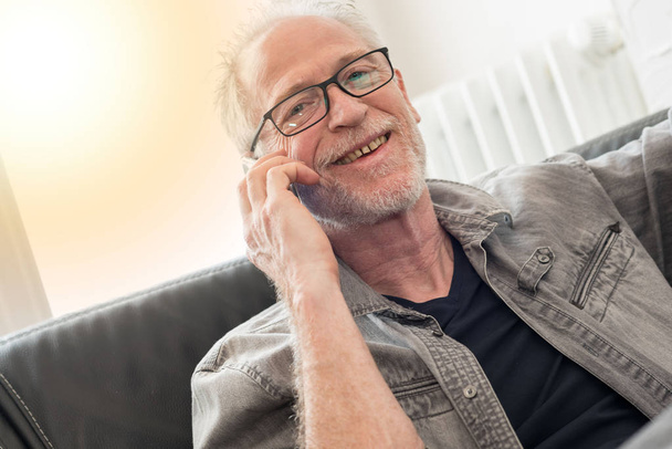Портрет усміхненого зрілого чоловіка, що розмовляє по телефону, легкий ефект
 - Фото, зображення