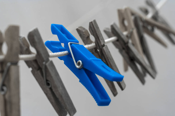 Blue clothes peg among wooden clothes pegs - Photo, Image