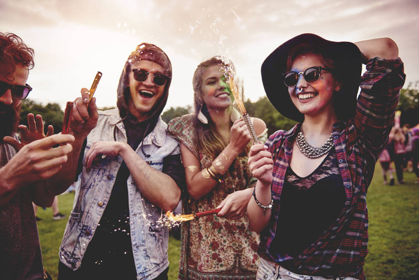 Group of friends holding fireworks at festival  - Photo, Image