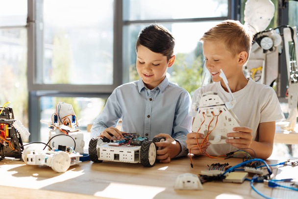 boys examining new robots - Foto, afbeelding