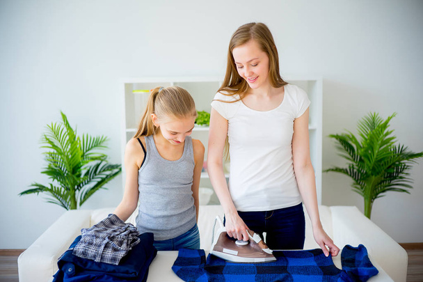 Mother and daughter doing laundry - Fotoğraf, Görsel