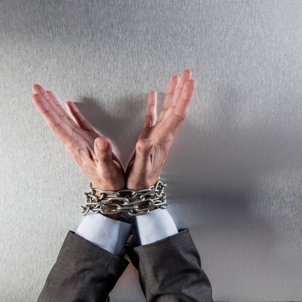 innocent professional man hands tied with chain for suspicious management - Foto, immagini