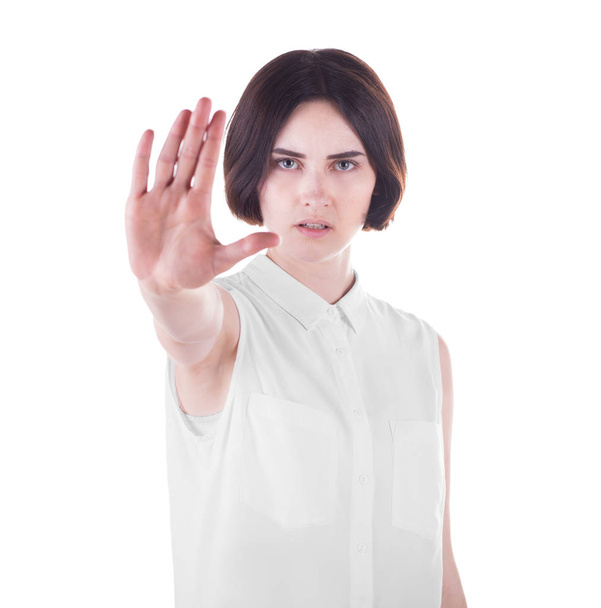 A beautiful young woman is making stop gesture with her right hand, isolated on a white background. Protest concept. A young angry woman showing stop hand. - Foto, Bild
