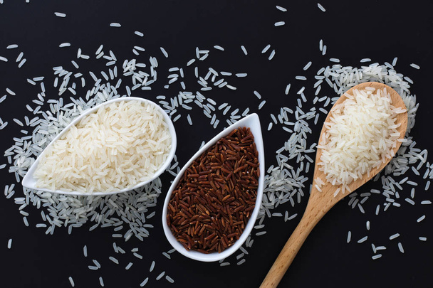 3 вида сырого тайского риса Жасминовый рис (Hom Mali), глютиновый / липкий рис (Khao Neow), коричневый рис (Khao Dum) в белых чашках на черном фоне с копировальным пространством
 - Фото, изображение