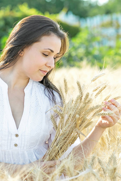 Hermosa mujer sexy joven sosteniendo espigas de trigo en verano día soleado. Retrato de chica bonita al aire libre
 - Foto, imagen