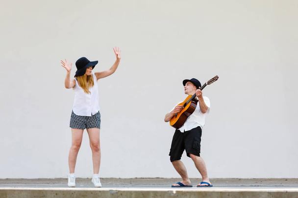 Man playing guitar, woman having fun - Фото, зображення