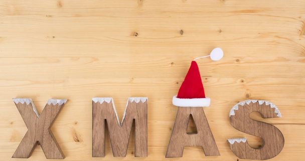 X Mas op hout en de Kerstman hoed - Foto, afbeelding