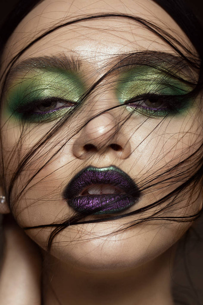 Beautiful girl with spring green makeup and vampire lips. beauty face. - Foto, Imagem