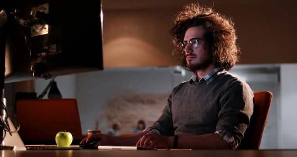 man working on computer in dark office - Photo, Image