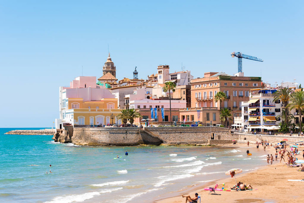 Sitges, Catalunya, Španělsko - 20 června 2017: Pohled na pláž a do historického centra. Prostor pro text kopírovat. Izolované na modrém pozadí. - Fotografie, Obrázek