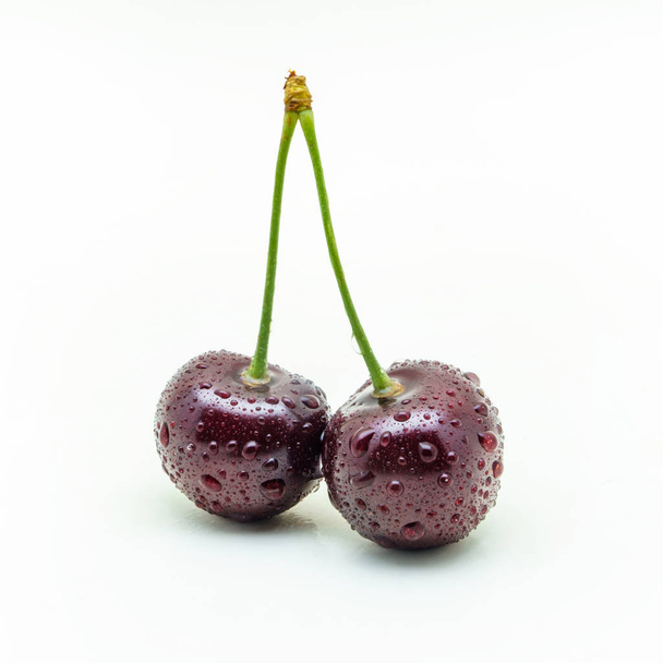 Two connected wet cherries on a white background - Photo, Image